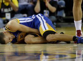 Golden State Warrior all-star guard Stephen Curry writhes in pain after suffering a sprained ankle. He also experienced a knee sprain and will be out of action until the end of April. (Image: Time Sports)