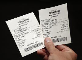 A bettor holds two tickets for bets made at the Race and Sports Book at Dover Downs Hotel and Casino in Delaware on June 5. (Image: Patrick Semansky/AP)