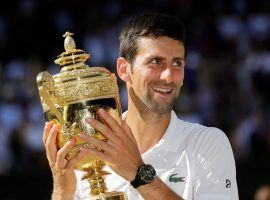 Novak Djokovic holds his trophy after winning the men’s singles final over Kevin Anderson in the 2018 Wimbledon tennis tournament. (Image: Ben Curtis/AP)