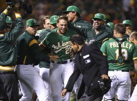 Matt Olson is mobbed by his teammates after he hit a walk-off home run to defeat Houston on Saturday. (Image: AP)