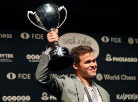 Magnus Carlsen holds the World Chess Championship trophy after defeating Fabiano Caruana in rapid tiebreaks to retain the title. (Image: Tolga Akmen/AFP/Getty)
