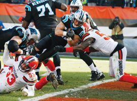 Carolina running back Christian McCaffrey (22) lunges into the end zone for a touchdown against the Browns in Cleveland. (Image: Ron Schwane/AP)