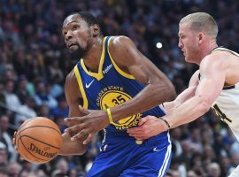Mason Plumlee from the Nuggets grabs Kevin Durant from the Golden State Warriors as he drives to the basket at the Pepsi Center in Denver, Colorado. (Image: Jerliee Bennet/Gazette)
