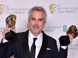"Roma" director Alfonson Cuaron poses with awards for Best Film and Best Director at the British Academy Film Awards at the Royal Albert Hall in London. (Image: Tolga Akmen/AFP)