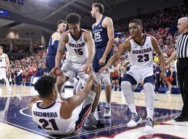 Gonzaga teammates Brandon Clarke (15) and Zach Norvell (23) help Rui Hachimura (21) off the floor against BYU in Spokane, WA. (Image: James Snook/USA Today Sports)