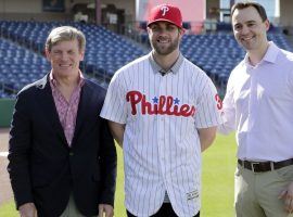 Bryce Harper (center) signed with the Philadelphia Phillies on Saturday, after which his new jersey broke the record for first day online sales. (Image: Lynne Sladky/AP)