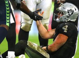 Oakland Raiders QB Derek Carr is helped up by after being knocked down in a game against the Seattle Seahawks in Oakland, CA. (Image: Warren Little/Getty)