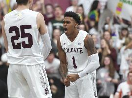 Colgate guard Jordan Burns (1) celebrates hitting a three-point shot with teammate Rapolas Ivanauskas (25) against Bucknell in the Patriot League Championship in Hamilton, New York. (Adrian Kraus/AP)