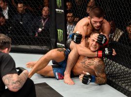 Khabib Nurmagomedov (top) works to submit Dustin Poirier during their main event title fight at UFC 242. (Image: Getty)
