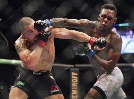 Israel Adesanya (right) hits Robert Whittaker (left) during their fight at UFC 243. (Image: AP)