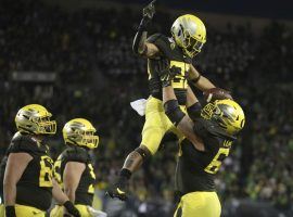 Oregon RB Cyrus Habibi-Likio is picked up by Shane Lemieux after their victory against Cal in Eugene, OR. (Image: Chris Pietsch/AP)