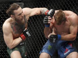Conor McGregor (left) punches Donald Cerrone (right) during their fight at UFC 246 on Saturday. (Image: AP)