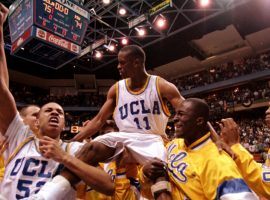 The UCLA Bruins carry point guard, Tyus Edney, off the court after he hit a buzzer-beater to defeat Missouri in the second round of the 1995 March Madness tournament. (Image: Bill Haber/AP)