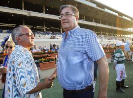 John Sadler, seen here shaking hands with owner Kosta Hronis after their Accelerate won the 2018 Pacific Classic. will sit out the next 15 days. Three of his horses tested positive for banned substances. (Image: Hayne Palmour IV/San Diego Union-Tribune)