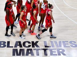 Atlanta Dream players walk by a Black Lives Matter graphic at the Feld Entertainment Center in Florida. Dream co-owner was critical of WNBA's BLM messaging.