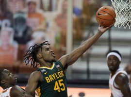 Baylor guard Davion Mitchell blows by a Texas defender during their last game before COVID-19 cancellations sidelined the Bears. (Image: Eric Gay/AP)
