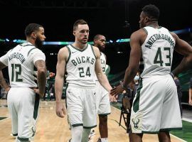 DJ Augustin (12), Pat Connaughton (24), and the Greek Freak (43) assemble during a time out at Fiserv Arena in Milwaukee. (Image: Nick Monroe/USA Today Sports)