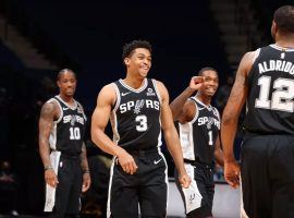 An upbeat Keldon Johnson (3), seen here grinning after hitting a 3-point shot for the San Antonio Spurs, will have to wait another week to play due to the NBA's COVID-19 safety protocols. (Image: David Sherman/Getty)