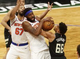 Mitchell Robinson, starting center for the New York Knicks, grabs a rebound against the Milwaukee Bucks before his injury. (Image: Jeff Hanisch/USA Today Sports)