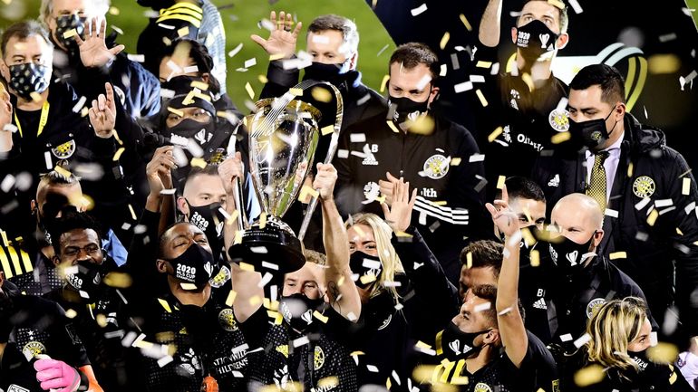 Members of MLS Columbus Crew hold up Philp F. Anschutz Cup after their 2020 MLS Cup victory.