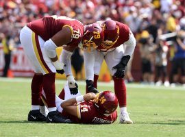 Washington Football Team teammates attend to quarterback Ryan Fitzpatrick after he suffered a hip injury in Week 1. (Image: Rob Carr/Getty)