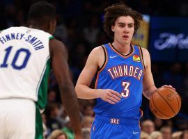 Josh Giddey from the Oklahoma City Thunder is defended by Dorian Finney-Smith of the Dallas Mavericks during his record-setting triple-double. (Image: Porter Lambert/Getty)