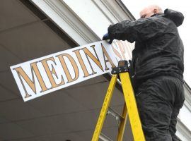 Tuesday morning, Churchill Downs' workers literally take down the sign marking Medina Spirit's 2021 Kentucky Derby victory. (Image: Coady Photography)