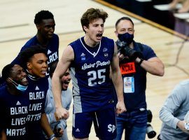 Saint Peter's guard Doug Edert (25) celebrates another win with his teammates against Purdue in the Sweet 16. (Image: AP)