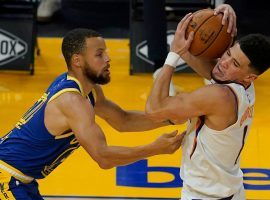 Steph Curry from the Golden State Warriors defends Devin Booker from the Phoenix Suns. (Image: Getty)