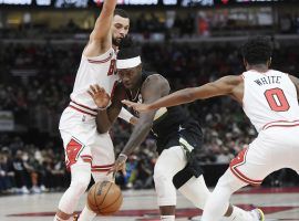 Jrue Holiday from the Milwaukee Bucks splits defenders Zach LaVine and Coby White from the Chicago Bulls. (Image: Paul Beaty/AP)