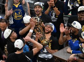 Steph Curry fondles the championship trophy while surrounded by teammates from the Golden State Warriors after they defeated the Boston Celtics in Game 6 of the NBA Finals at TD Garden. (Image: Bob DeChiara/USA Today Sports)