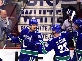 Apr 5, 2018; Vancouver, British Columbia, CAN; Vancouver Canucks forward Henrik Sedin (33) celebrates forward Daniel Sedin (22) goal against Arizona Coyotes goaltender Darcy Kuemper (35) (not pictured) during the second period at Rogers Arena. Mandatory Credit: Anne-Marie Sorvin-USA TODAY Sports