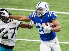 Jonathan Taylor, running back from the Indianapolis Colts, stiff arms a defender from the Jacksonville Jaguars last season in an AFC South division game. (Image: Don Becker/Getty)